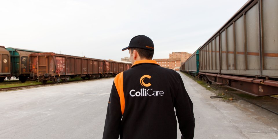 An employee in branded clothes from behind, walking towards the parked train at the railway station